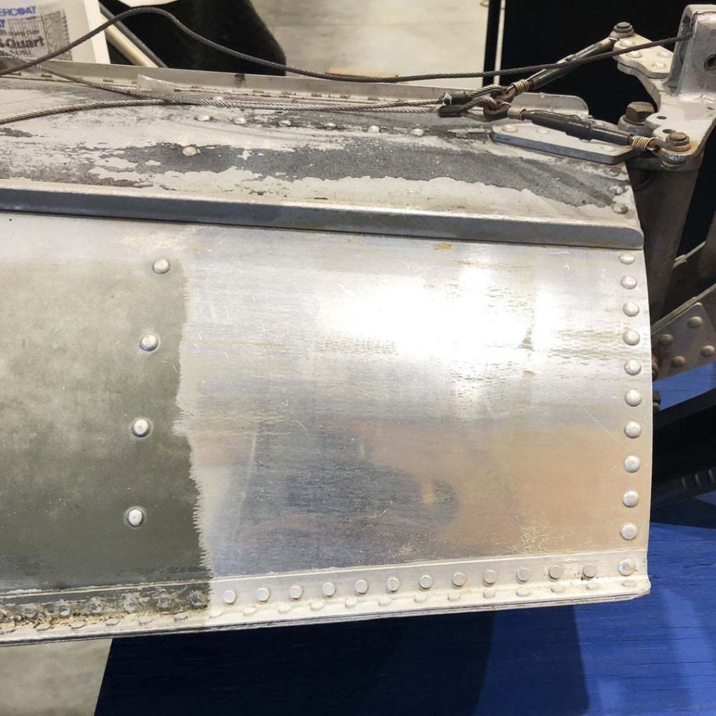 Closeup of the end of a metal boat, with one clean, shiny area that has been cleaned with a laser cleaning machine