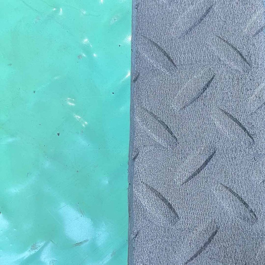 Closeup of a textured metal surface. One half has a layer of turquoise paint, the the other half is bare metal after laser cleaning.